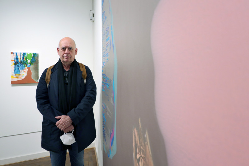 Michael Bause steht links von seinem Werk in der Ausstellung
