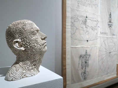 Héctor Velázquez, self-portrait, 2018 (sculpture on the left), in the background the wallpaper series by Sandra Contreras 