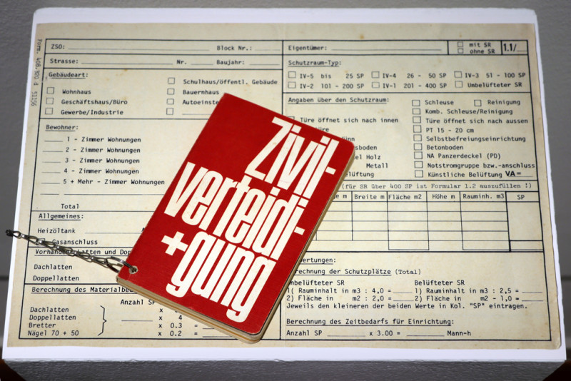 Installation von Informationsmaterial und einem Buch aus den 70er Jahren aus einer Bunkeranlage in der Schweiz.