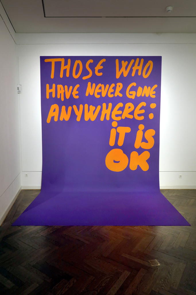 Large purple poster with orange lettering: 
