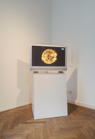 Flachbildschirm auf weißem Sockel zeigt eine Aufnahme der Sonne von der NASA