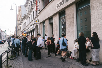Menschenmenge sammelt sich vor der Galerie in Gesprächen