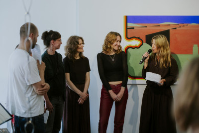 Group photo at the opening of the exhibition nebula at Galerie im Saalbau: from left to right Louis Hay, Ani Schulze, Nina Laaf, Jana Schulz, Isabella Fürnkäs, and curator Diana Nowak (right) standing side by side in front of the audience.