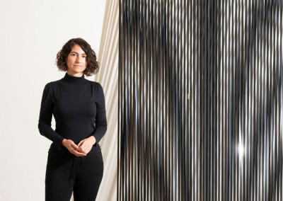 Porträt der Künstlerin Vanessa Enriquez vor ihrer Arbeit.