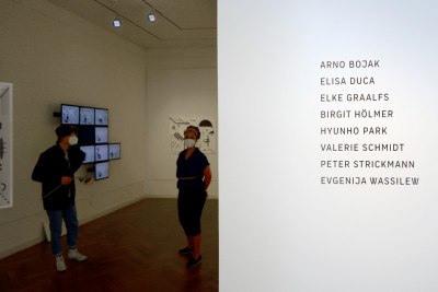 auf der linken Seite stehen auf der Wand die Namen der Nominierten auf der rechten Seite des bildes öffnet sich der Blick in den Ausstellungsraum