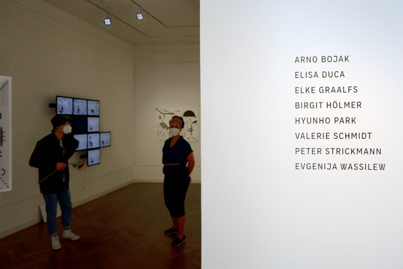 auf der linken Seite stehen auf der Wand die Namen der Nominierten auf der rechten Seite des bildes öffnet sich der Blick in den Ausstellungsraum