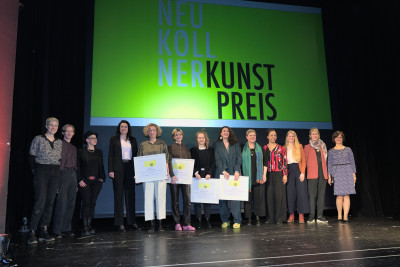 The award winners stand on the stage of Heimathafen Neukölln together with the jury and the city councillor for culture