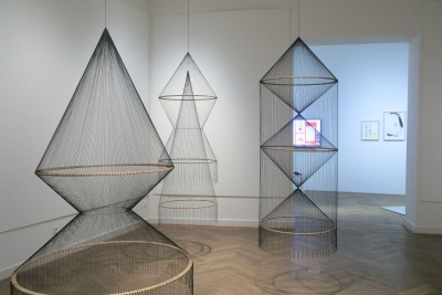 The picture shows hanging filigree objects made of wooden hoops and black cotton threads