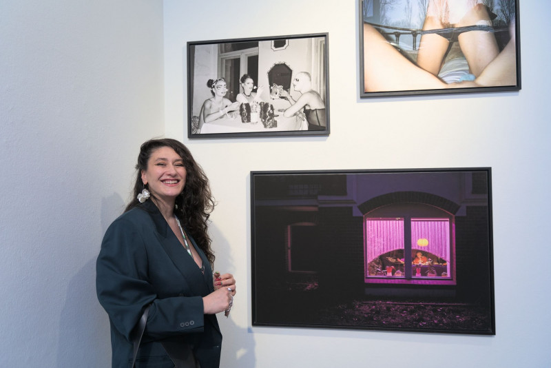 The artist and winner of the Neukölln Art Prize 2024 stands in front of three photographic works from the series 