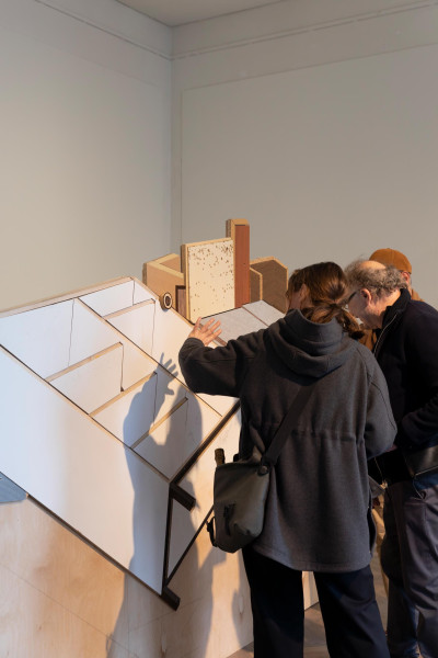 Two visitors examining an wooden art installation
