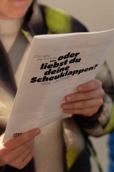 Person reading a program during an exhibition opening