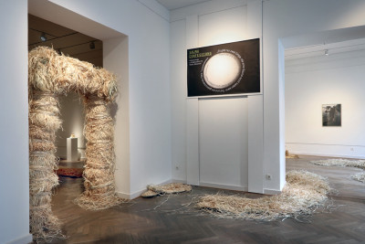 Portal aus Raffia und Plakat für die Ausstellung von Sauna Confessions