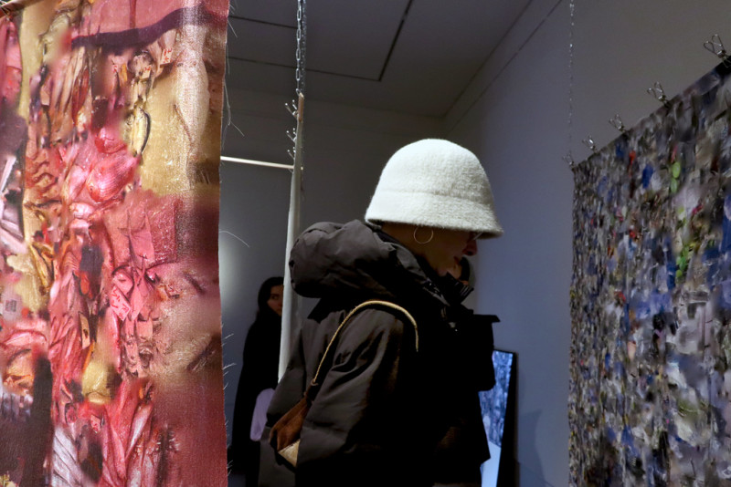 Im Vordergrund ein Stoffbanner mit Bildfragmenten, dahinter ist eine Person zu sehen