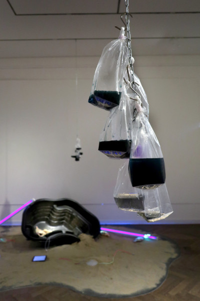 Detailed view: Chains hanging from the ceiling with bags filled with slime.