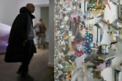 In the foreground a fabric banner with fragments of a picture, behind it a person can be seen dimly