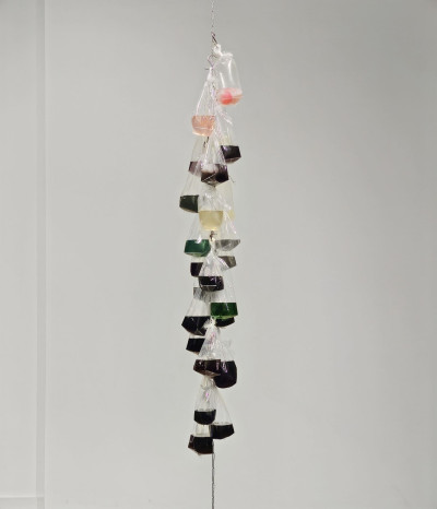 Detailed view: Chain hanging from the ceiling with bags filled with slime.