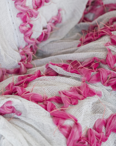 Pink tulle is attached to a white dust net.