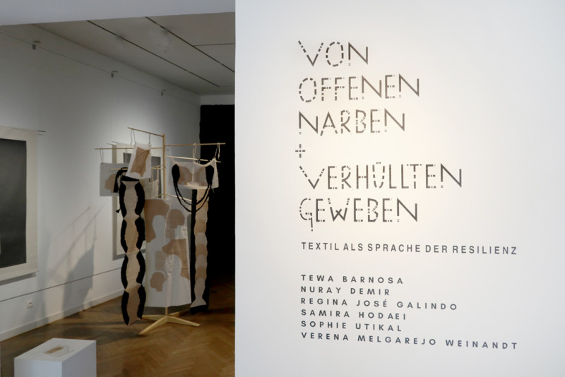 Titel der Ausstellung auf der rechten Seite und Blick in die Ausstellung auf der linken Seite