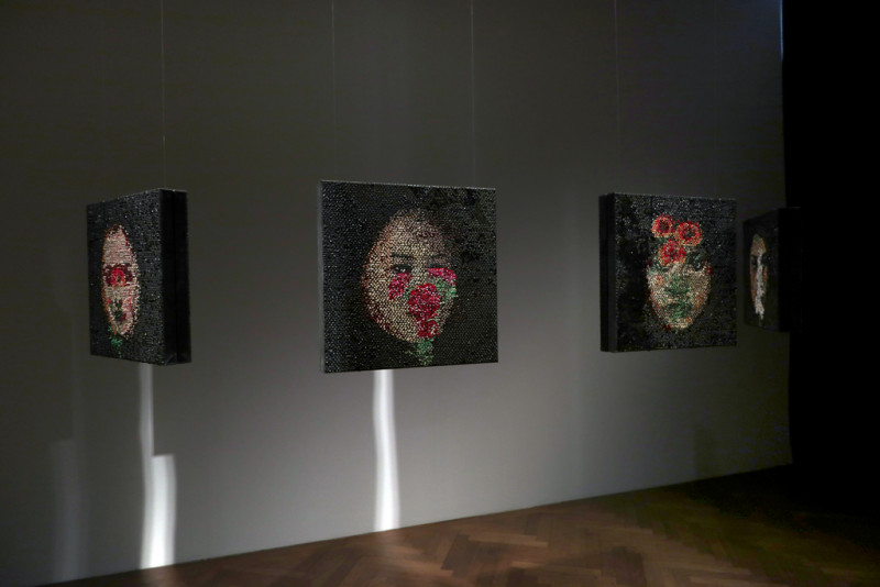 Frauenporträts hängen im Raum