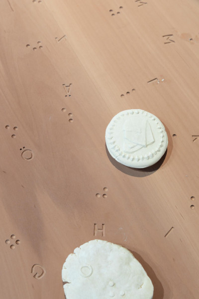 Bildgebäck auf Holzplatte mit Brailleschrift