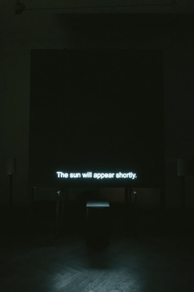 Dark gallery interior with neon text reading 