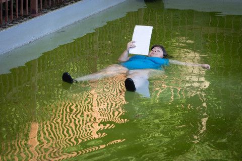 Die Künstlerin liest auf dem Rücken schwimmend in einem Brunnen vor