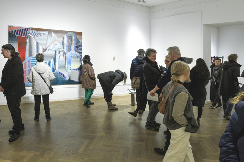 Visitors walk through the exhibition in the gallery